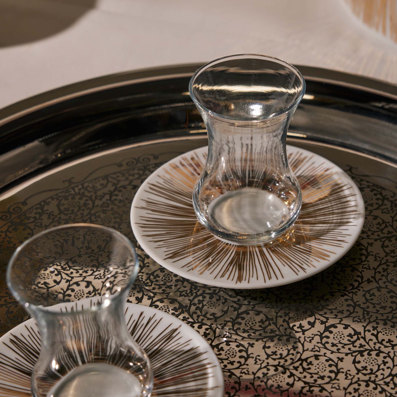 طقم تمرة بالتعاون مع رزان العزوني سترايبس المؤلف من فنجانين عربيين للشاي مع صحنيهما باللون الذهبي صلصال طقم تمرة بالتعاون مع رزان العزوني سترايبس المؤلف من فنجانين عربيين للشاي مع صحنيهما باللون الذهبي