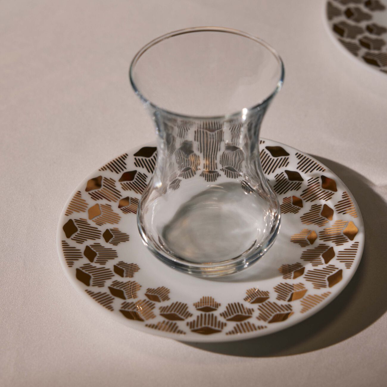 طقم تمرة بالتعاون مع رزان العزوني لونا المؤلف من فنجانين عربيين للشاي مع صحنيهما باللون الذهبي صلصال طقم تمرة بالتعاون مع رزان العزوني لونا المؤلف من فنجانين عربيين للشاي مع صحنيهما باللون الذهبي